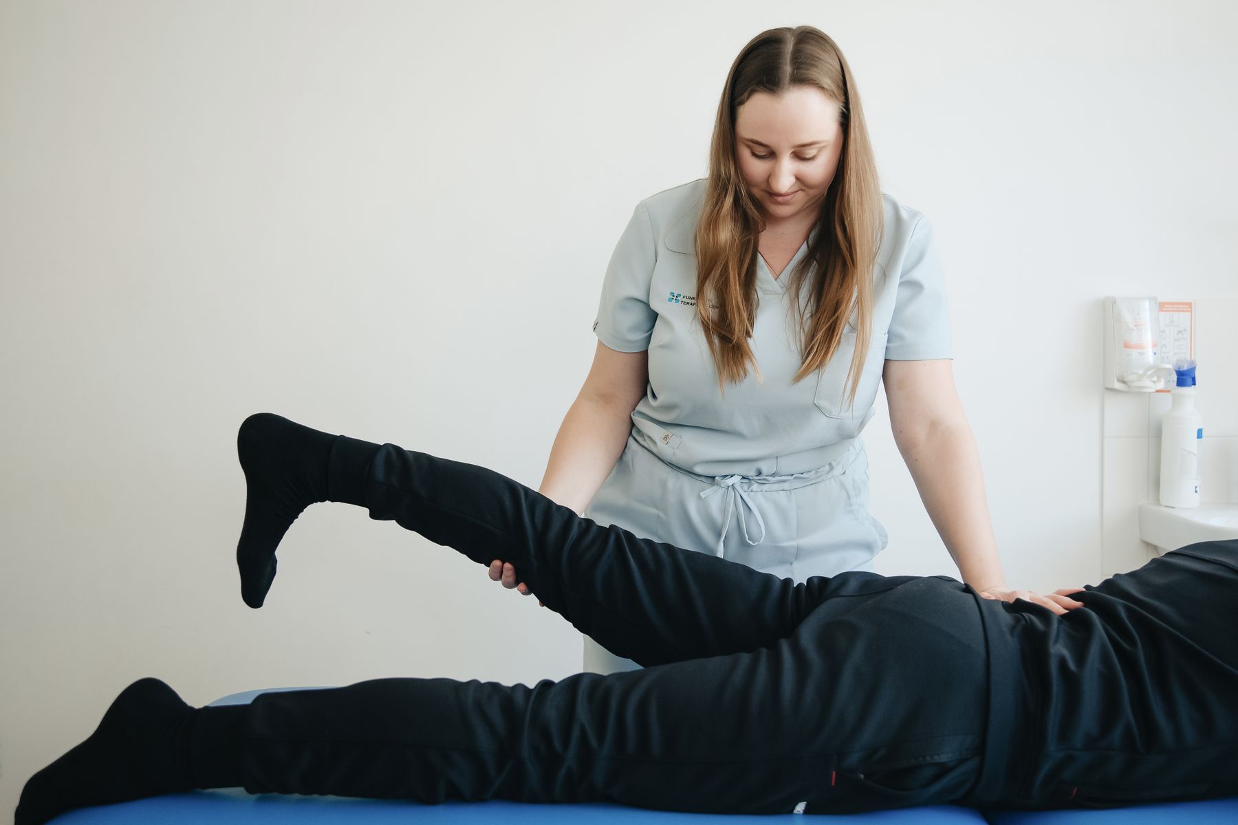 Physiotherapeutin begleitet eine Patientin bei einer Beinbewegung